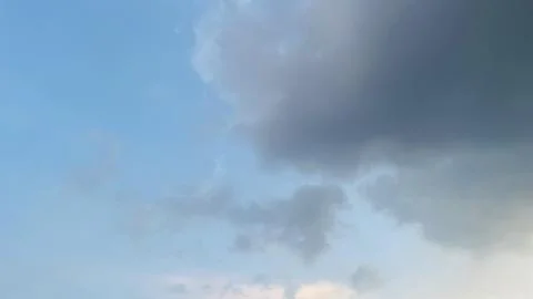 Wide Angle View of Light Blue Sky and Rolling Dark Cumulus Clouds Stock Photos