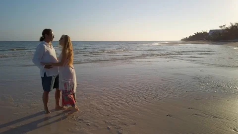 Wide angle view of mature couple on a beach looking at each other dancing. Stock Footage 104015789