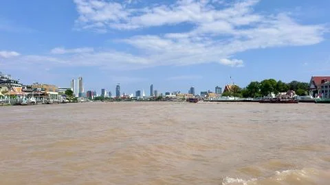 Wide angle view from the middle of Chao Phraya River towards the riverside Stock Photos
