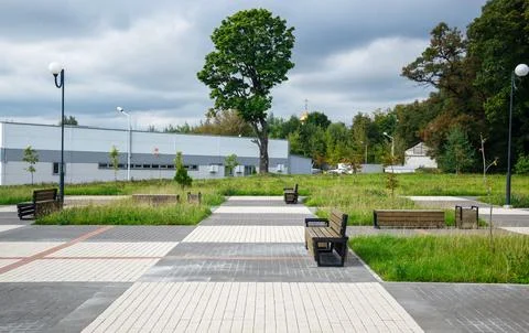 Wide angle view of modern public recreational park square with wooden bench Stock Photos