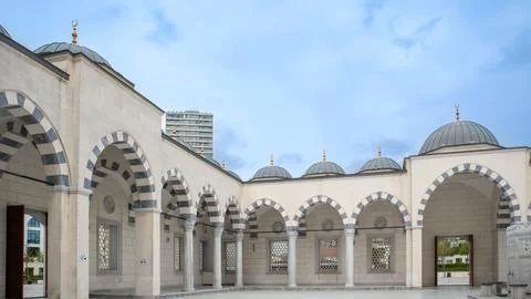 Wide angle view of mosque courtyard with stone arches and domes in a modern.. Photos