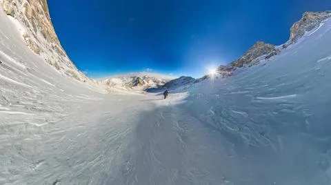 Wide-angle view of a mountain hiker to climb a mountain of snow couloir Stock Photos