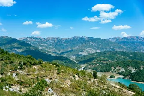 Wide angle view of a mountainous landscape with a big blue sky and some clouds Stock Photos