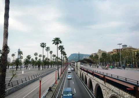 A wide-angle view of a multi-lane highway with traffic, lined on both sides b Stock Photos
