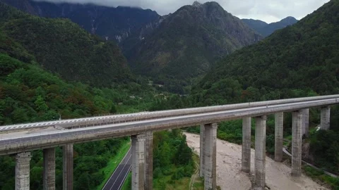 Wide-angle view of multi-span concrete bridge crossing mountain valley Video stock 342507144