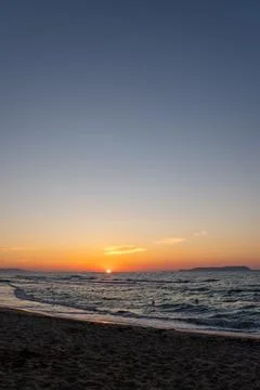 Wide angle view of orange sunset over sea with sandy beach shore Fotos Stock