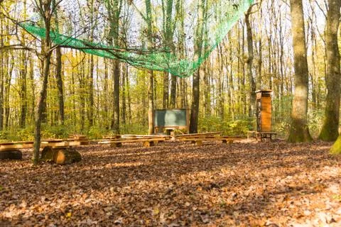 Wide angle view on outdoor class room in forest with chalk board, school desk Stock Photos