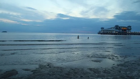 Wide angle view of people playing in the sea as night falls Stock Footage 114007151