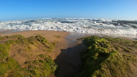 Wide angle view of a seaside wave rushing over rocks. Stock Footage 122105136