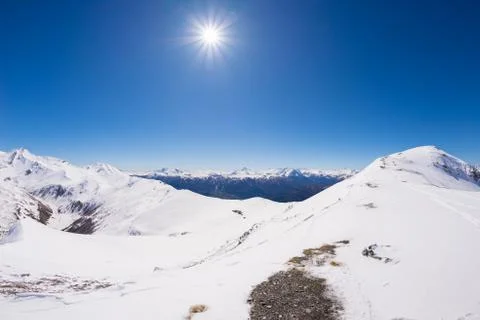 Wide angle view of a ski resort in the distance with elegant mountain peaks a Stock Photos