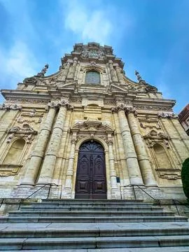 Wide-angle view of a stunning baroque church facade in Leuven under blue sky Stock Photos