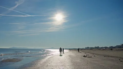 Wide-angle view of a sunny beach at midday with bright sun flare Stock Footage 328463231