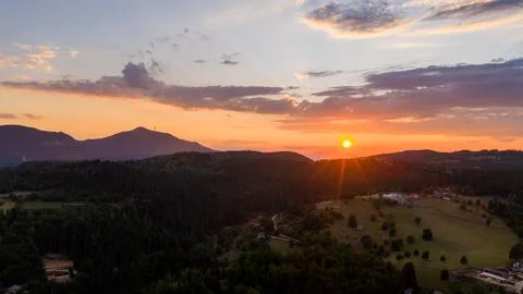 A wide-angle view of sunset illuminating a layered mountain landscape with fo Stock Photos