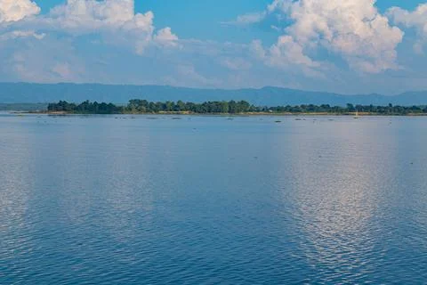 Wide-angle view of tranquil Kaptai Lake surrounded by greenery with floating Stock Photos