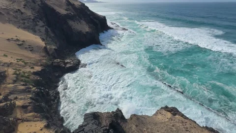 Wide angle view of turquoise waves hitting rocky coastal cliffs 스톡 동영상 331195678
