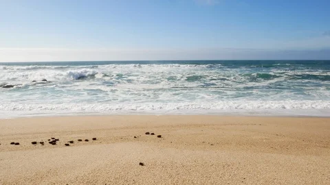 Wide angle view of waves breaking on sandy beach Stock Footage 104445927