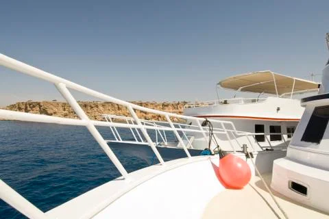 Wide-angle view of a white dive-boat's bow. 库存照片