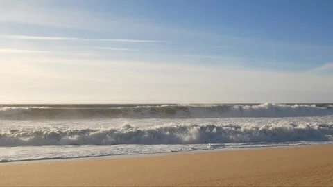 Wide angle waves crashing on shore of empty sandy beach on a sunny day Stock Footage 103279352