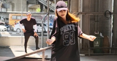 Wide angle of young man and woman doing freestyle street dancing with street Stock Footage 106377839