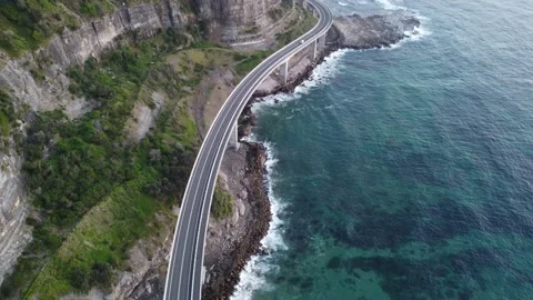 Wide angled drone shot from the top of a bridge with grassland and waves Stock Footage 143620301