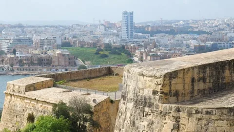 Wide bastion wall panorama frames the sliema skyline garden pathway winding Stock Footage 341803673
