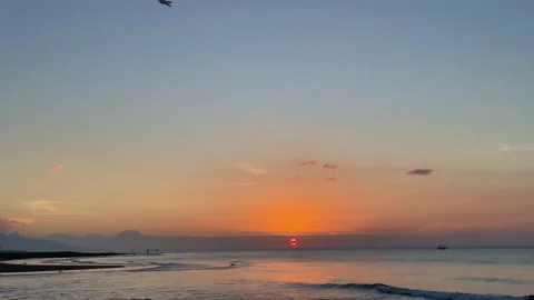 Wide beach sunset with distant mountain silhouette in Bali Stock Footage 337857808