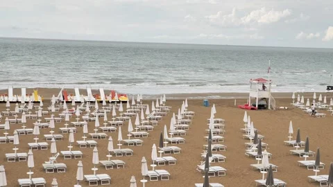 Wide beach view with neatly arranged white sun loungers Vidéo 314595515