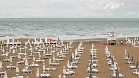 Wide beach view with neatly arranged white sun loungers 스톡 동영상 314595543