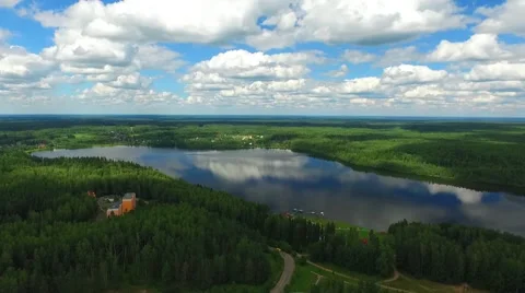 Wide beautiful lake with reflected sky on a sunny day and a few buildings Stock Footage 66514484