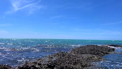 Wide blue ocean view with clear sky and rocky shore Stock Footage 310242045