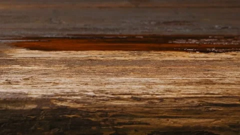 A wide brush covers a dark varnish on a faded wooden surface Vídeo Stock 215035534