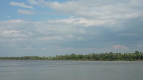 Wide calm river reflects beautiful blue sky filled with white clouds. Stock Footage 341689350