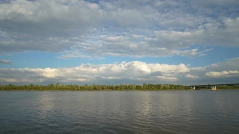 Wide calm river reflects beautiful blue sky filled with white clouds. Stock Footage 341689651