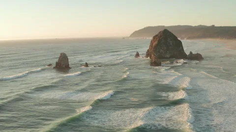 Wide circling aerial shot of Haystack rock at sunset Stock Footage 250591611