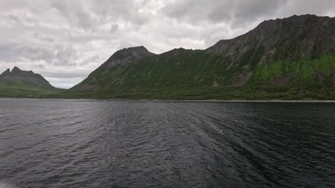 Wide clean view sailing past lush green mountain slopes in Gryllefjord Norway 動画素材 342755834