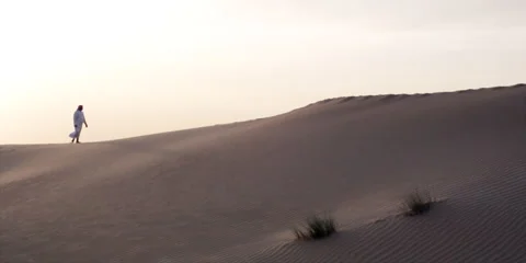 Wide close motion shot of an Arabic man walking on a desert. Video stock 46871250