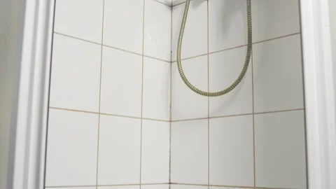 Wide close-up of a shower base corner with stained caulk along the rim and Видео 325842996