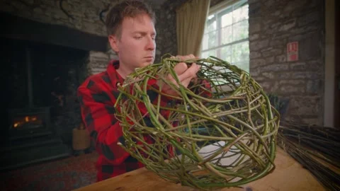 Wide Close Up Of Traditional Weaver Using Foraged Willow To Make Basket Video stock 253338049