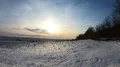 Wide country panning shot over snow-white frozen farmland at sunset in winter 4k or 4k+ Resolution
