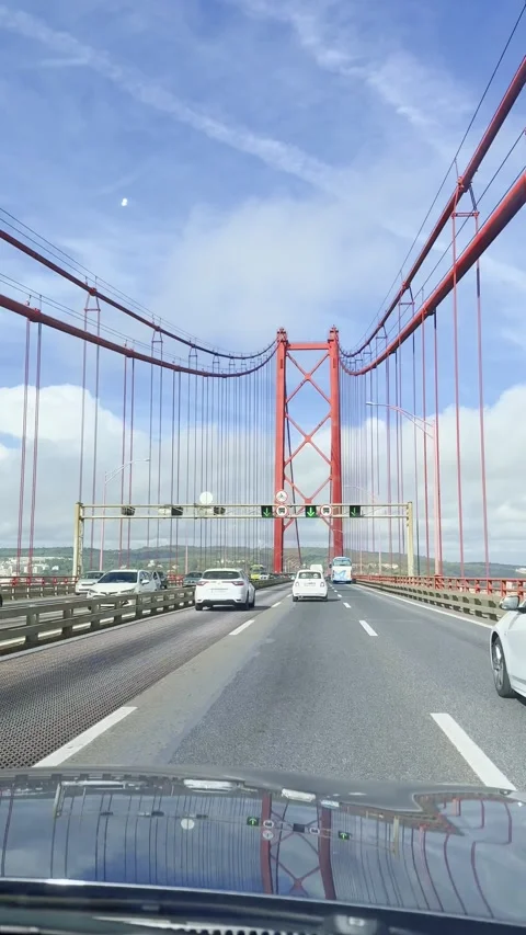 Wide dashboard shot of 25 de Abril Bridge Lisbon with iconic red towers and Stock Footage 318913484
