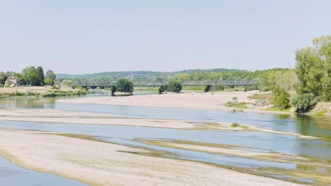 Wide daylight view of the Loire River with visible sandbanks and a metal bridge Stock Footage 346667478