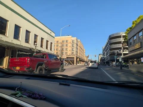 Wide downtown street bordered by a multi-level parking garage Фото