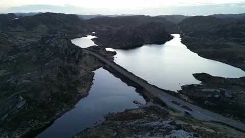 Wide drone arc over A838 NC500 road crossing Loch na Thull, Sutherland Stock Footage 323434977