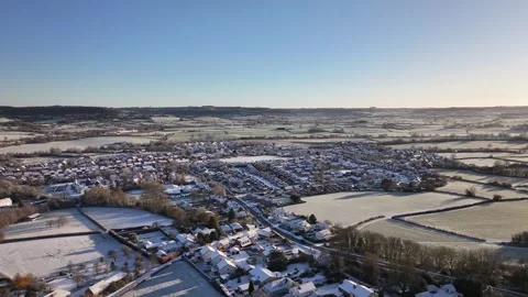 Wide Drone Pan over Snow Covered UK Villlage at sunrise in 4K Видео 329968252