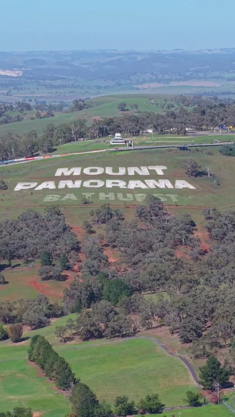 Wide drone panorama overlooking the Mount Panorama Circuit hillside sign, r.. Stockbeeldmateriaal 335000592