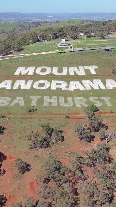 Wide drone panorama overlooking the Mount Panorama Circuit hillside sign, r.. Видео 335000624