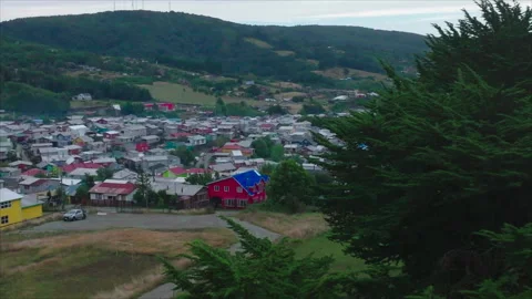Wide drone passing tree rotating to reveal city, Puerto Montt Stock Footage 340992718