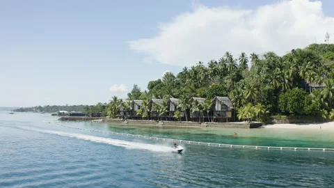 Wide Drone Scene of Jet Ski Near Tropical Beachfront Villas Stock Footage 237973551