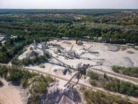 Wide drone shot captures active stone crushing plant with conveyor systems, h Photos
