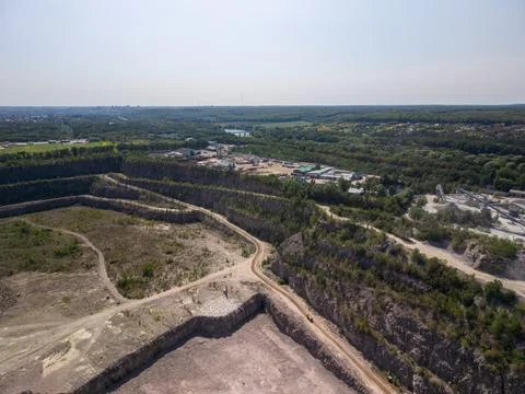 Wide drone shot captures massive open pit stone quarry showing deep rocky ter Fotos Stock